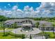 Aerial view of the community clubhouse with a circular driveway, porte cochere, and manicured landscaping at 131 Longridge Ln, Ormond Beach, FL 32174