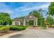 Scenic entrance to the gated community with lush landscaping and a welcoming gatehouse at 131 Longridge Ln, Ormond Beach, FL 32174