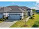 Home featuring a gray-tone garage door, manicured landscaping, and a beautiful walkway at 131 Longridge Ln, Ormond Beach, FL 32174