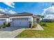 Home with a gray-tone garage door, beautifully manicured landscaping, and a walkway at 131 Longridge Ln, Ormond Beach, FL 32174