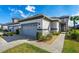 Home with a gray-tone garage door, manicured landscaping, and a welcoming walkway at 131 Longridge Ln, Ormond Beach, FL 32174