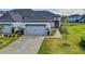 Charming home featuring a gray-tone garage door, lush landscaping, and a welcoming walkway at 131 Longridge Ln, Ormond Beach, FL 32174