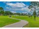 Scenic golf course with a paved cart path, lush green fairway, and players in the distance at 131 Longridge Ln, Ormond Beach, FL 32174