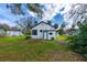 View of the home from backyard featuring green grass and mature trees at 134 Knight Pl, Daytona Beach, FL 32114