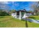 Attractive exterior showcasing covered porch, green lawn, gray walkway, and black trim windows at 134 Knight Pl, Daytona Beach, FL 32114