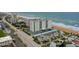 Aerial view of the condo building on the ocean with views of the beach, parking, and surrounding neighborhood at 1415 Ocean Shore Blvd # L1, Ormond Beach, FL 32176