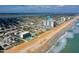 Wide aerial shot of the condo building on the beach, showcasing the pool, ocean views, and surrounding area at 1415 Ocean Shore Blvd # L1, Ormond Beach, FL 32176