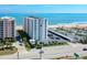 Aerial view of a condo building near the beach and ocean, with parking, landscaping, and surrounding roads at 1415 Ocean Shore Blvd # L1, Ormond Beach, FL 32176