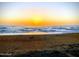 A serene beach view highlighting the ocean waves and sandy shoreline at sunrise at 1415 Ocean Shore Blvd # L1, Ormond Beach, FL 32176