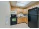 The kitchen features light wood cabinets and a black refrigerator and stove at 1415 Ocean Shore Blvd # L1, Ormond Beach, FL 32176