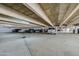 Parking garage view with a concrete ceiling, parked cars and bright lights at 1415 Ocean Shore Blvd # L1, Ormond Beach, FL 32176