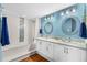 Bright bathroom featuring a double sink vanity, decorative mirrors, and a bathtub with stylish tile accents at 3333 S Atlantic Ave # 1802, Daytona Beach, FL 32118