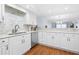 Modern kitchen featuring granite countertops, stainless steel sink, and white cabinetry at 3333 S Atlantic Ave # 1802, Daytona Beach, FL 32118