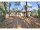 Backyard featuring mature trees, an exterior door, and a wood deck at 354 Fir St, Ormond Beach, FL 32174