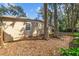 Back of house with mature trees and foliage in a large yard, and a wood fence at 354 Fir St, Ormond Beach, FL 32174