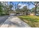 Single Gathering home with mature trees, front lawn and a paved driveway leading to an attached garage at 354 Fir St, Ormond Beach, FL 32174