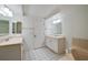 Bright bathroom featuring double sinks, vanity, and a tub with shower at 4555 S Atlantic Ave # 4609, Port Orange, FL 32127