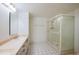 Bathroom featuring a double sink vanity with ample storage, tile flooring, and a glass-enclosed shower at 4555 S Atlantic Ave # 4609, Port Orange, FL 32127