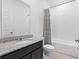 Neutral bathroom featuring a granite countertop, undermount sink, and tiled shower and floor at 806 Armenia Ct, New Smyrna Beach, FL 32168