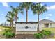 Coastal Woods community entrance sign featuring lush landscaping and swaying palm trees at 806 Armenia Ct, New Smyrna Beach, FL 32168