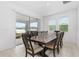 Bright dining room features a large wooden table, tile flooring, and sliding glass doors to the lanai at 806 Armenia Ct, New Smyrna Beach, FL 32168