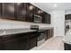 Elegant kitchen featuring dark cabinets, granite countertops, and stainless steel appliances at 806 Armenia Ct, New Smyrna Beach, FL 32168