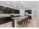 Modern kitchen featuring granite countertops, dark cabinetry, stainless steel appliances, and an island with bar stools at 806 Armenia Ct, New Smyrna Beach, FL 32168