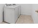 Bright laundry room featuring white appliances and tile flooring at 806 Armenia Ct, New Smyrna Beach, FL 32168