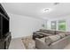 Comfortable living room featuring a gray sectional, ottoman, and entertainment center with natural light at 806 Armenia Ct, New Smyrna Beach, FL 32168