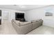 Spacious living room with tile floors, a large gray sectional, and an entertainment center at 806 Armenia Ct, New Smyrna Beach, FL 32168