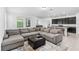 Open-concept living and kitchen with a gray sectional, ottoman, and island with barstool seating at 806 Armenia Ct, New Smyrna Beach, FL 32168