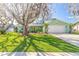 Charming single-story home featuring a manicured lawn, mature trees, and a welcoming two-car garage at 906 Timberwood Dr, Port Orange, FL 32127