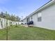 Grassy backyard featuring a grill, patio seating, and a view of the home's exterior at 113 Plumosus Park Dr, Deland, FL 32724