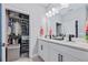 Bathroom featuring double sink vanity, closet, tile floors, and a large mirror at 113 Plumosus Park Dr, Deland, FL 32724