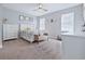 Bright bedroom with neutral carpet, ceiling fan, white furniture, and natural light at 113 Plumosus Park Dr, Deland, FL 32724