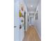 Long hallway with modern plank flooring, neutral paint and an array of artwork adorning the walls at 113 Plumosus Park Dr, Deland, FL 32724