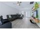 Bright living room featuring a large sectional sofa, modern ceiling fan, stylish decor, and durable floors at 113 Plumosus Park Dr, Deland, FL 32724