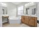 Elegant bathroom with a soaking tub, vanity area, and natural wood cabinets at 1143 Champions Dr, Daytona Beach, FL 32124