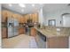 Well-lit kitchen with stainless steel appliances, wooden cabinets, and granite countertops at 1143 Champions Dr, Daytona Beach, FL 32124