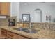 Close-up of a kitchen sink with granite countertops and stainless steel faucet and double basin sink at 1143 Champions Dr, Daytona Beach, FL 32124