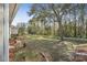 A home's tree-lined yard with manicured beds alongside a walking path that meanders into the trees at 1143 Champions Dr, Daytona Beach, FL 32124