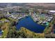 Aerial view of lakeside villas nestled around a large lake surrounded by lush greenery and landscaping at 150 Limewood Pl # F, Ormond Beach, FL 32174