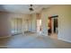 Bedroom featuring neutral carpeting, ceiling fan, closet, and doorway to ensuite bathroom at 150 Limewood Pl # F, Ormond Beach, FL 32174