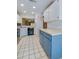 View of kitchen featuring white upper cabinets and trendy blue lower cabinets and modern appliances at 150 Limewood Pl # F, Ormond Beach, FL 32174