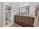 Bright bathroom featuring a granite vanity, large mirror, and a glass enclosed walk-in shower at 25 Misners Trl, Ormond Beach, FL 32174