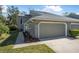 Charming exterior of a townhome featuring a well-maintained lawn, landscaping, and attached two-car garage at 25 Misners Trl, Ormond Beach, FL 32174