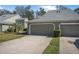 Charming exterior of a townhome featuring a well-maintained lawn, landscaping, and attached two-car garage at 25 Misners Trl, Ormond Beach, FL 32174