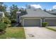 Charming exterior of a townhome featuring a well-maintained lawn, landscaping, and attached two-car garage at 25 Misners Trl, Ormond Beach, FL 32174