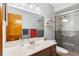 Tiled bathroom featuring a glass-enclosed shower, and a large wood framed mirror at 290 Birch Ave, Orange City, FL 32763