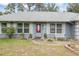 Close-up of the house featuring a grey exterior and a red front door at 290 Birch Ave, Orange City, FL 32763